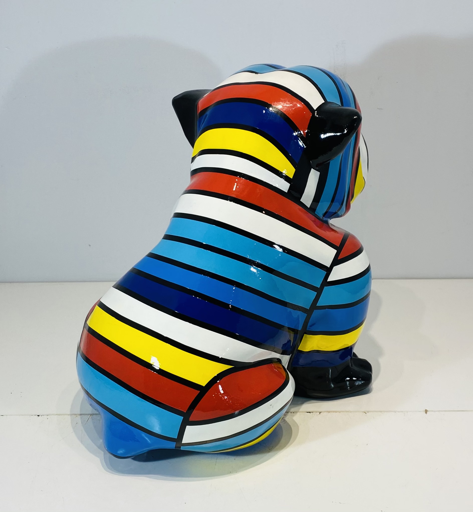 bouledogue assis en résine personnalisé par des rayures multicolores